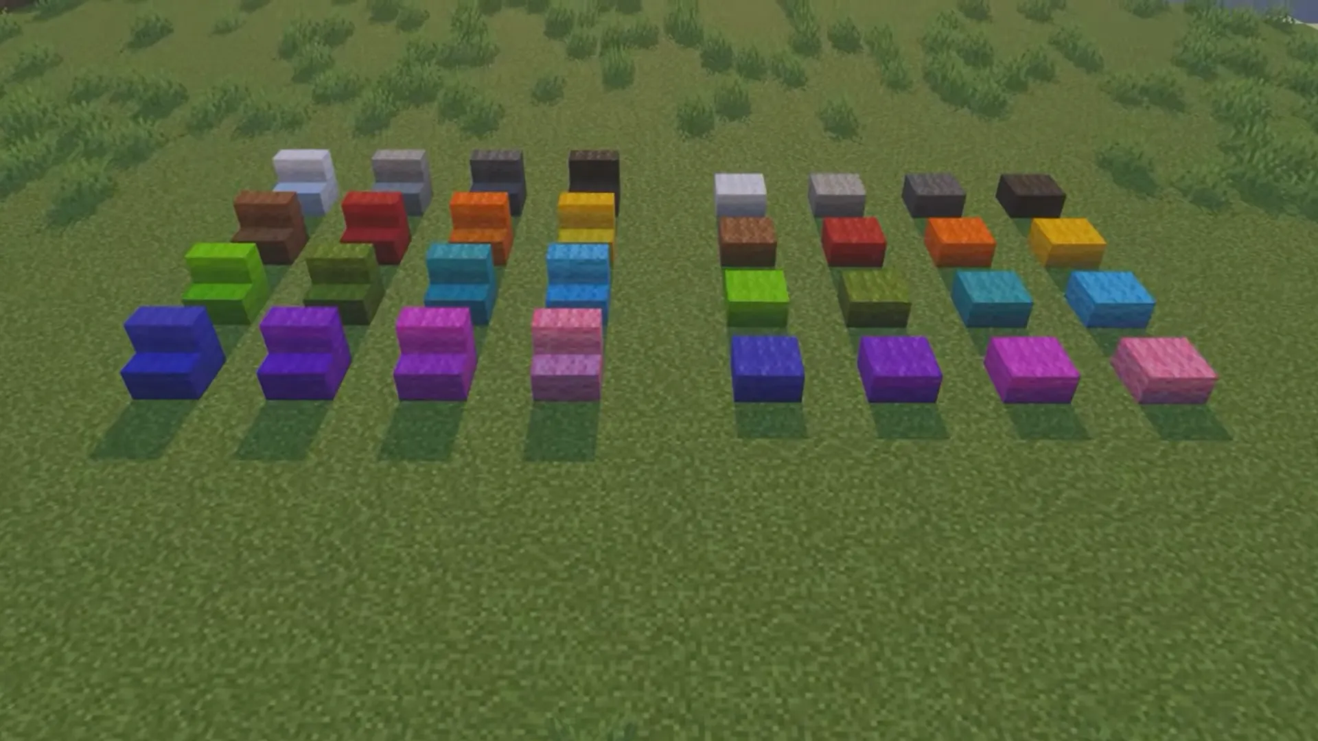 Rows of colorful wool stairs and slabs are arranged on grass in Minecraft.
