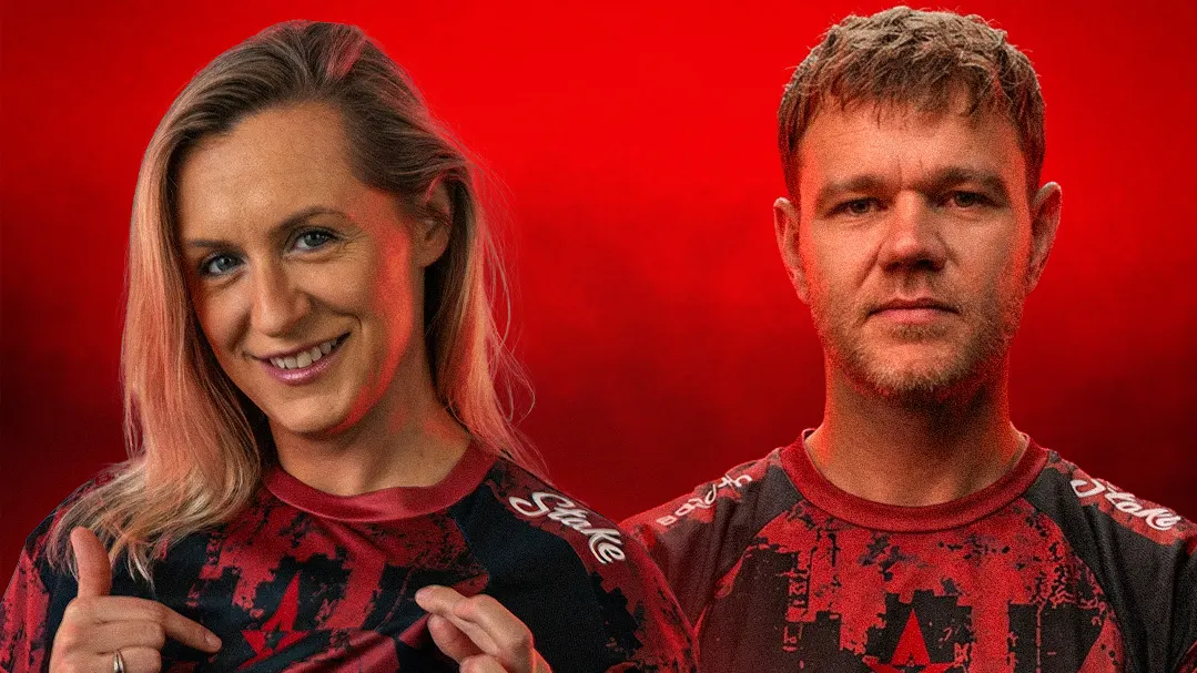 Xirreth and NEO pose in matching red and black Astralis jerseys against a bright red background.