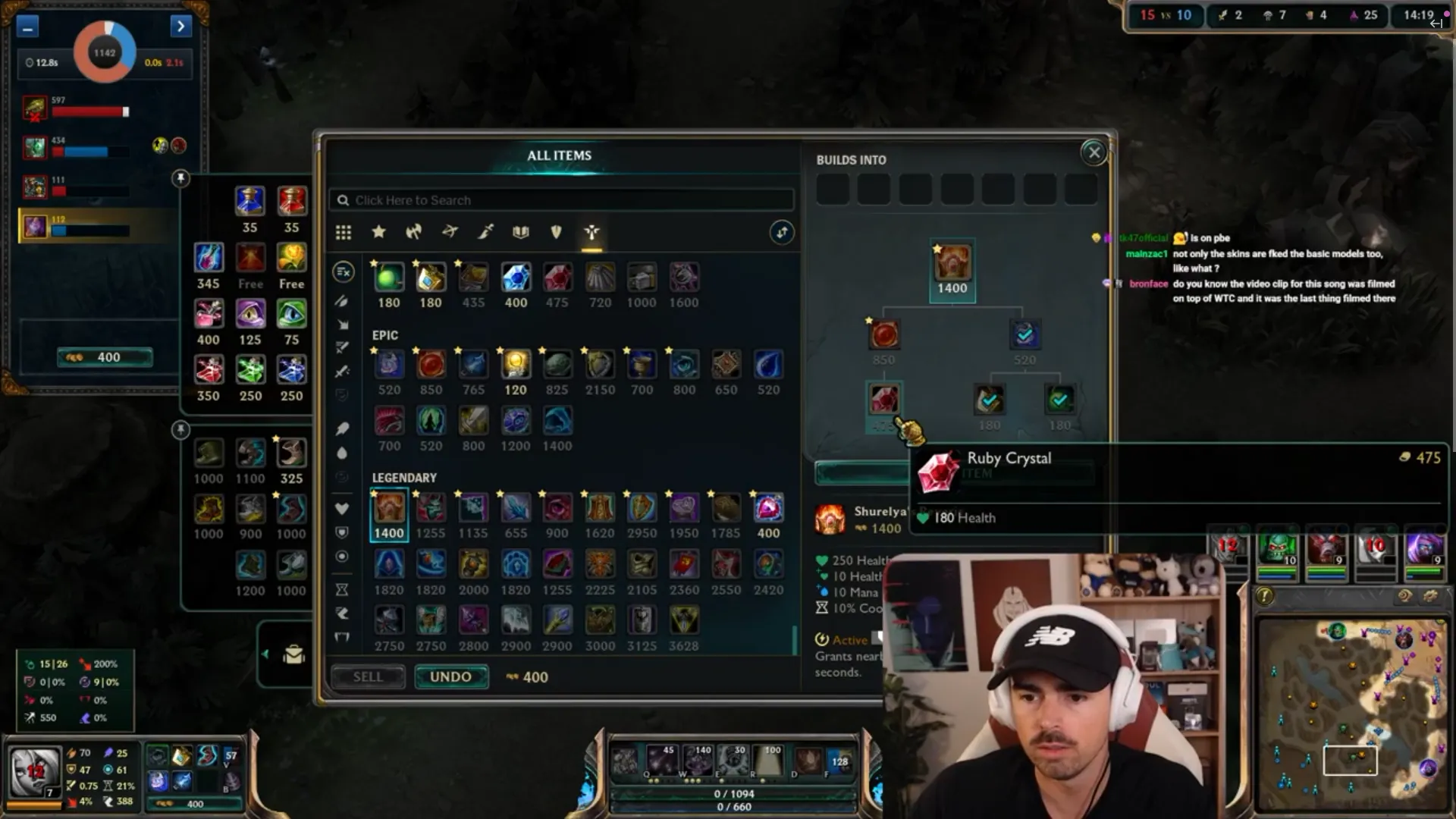 Streamer Midbeast opens the League of Legends item shop mid-game, shown in a webcam overlay wearing a white cap.