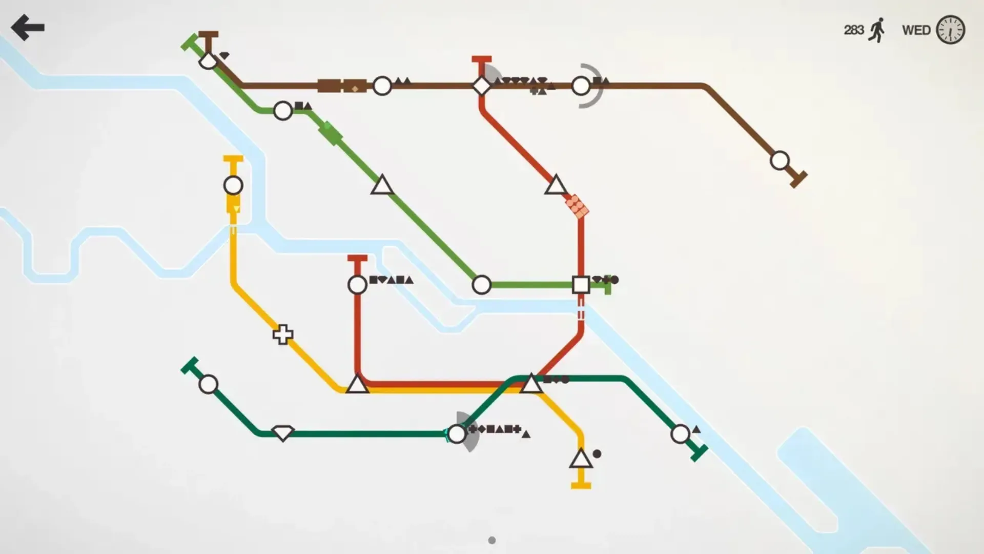 A minimalist Mini Metro subway map with colored lines connecting circle, triangle, and square stations across rivers.