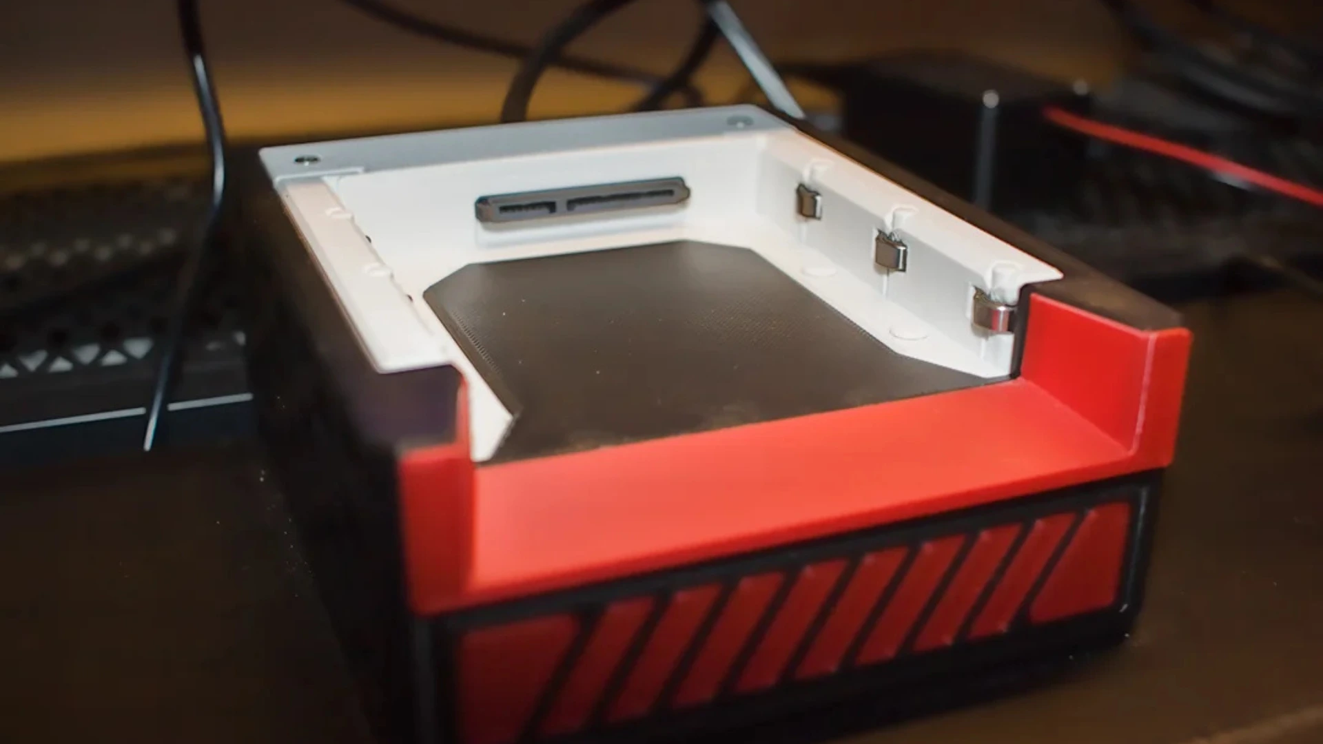 Open 3D-printed SSD cartridge dock with SATA connector and red trim