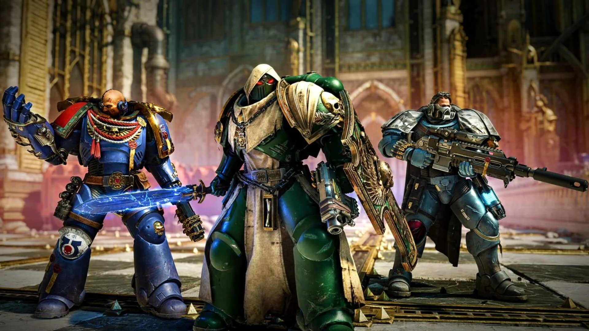 Three Space Marines in blue, green, and grey armour stand together inside a ruined imperial building.