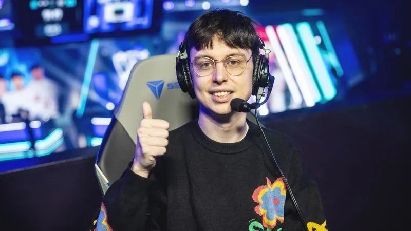 Caedrel wearing a headset and giving a thumbs-up at a League of Legends esports event.