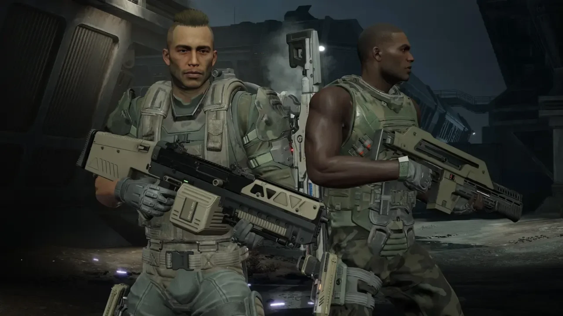 Two Colonial Marines stand armed with pulse rifles inside an industrial facility in Aliens: Fireteam Elite 2.