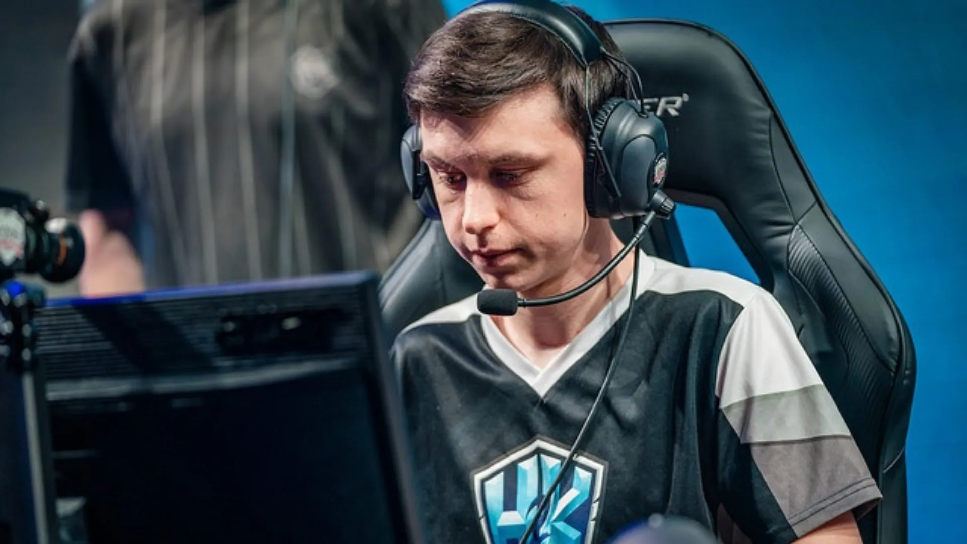 A younger Caedrel in a dark team jersey and headset concentrates on his monitor during an LEC match.