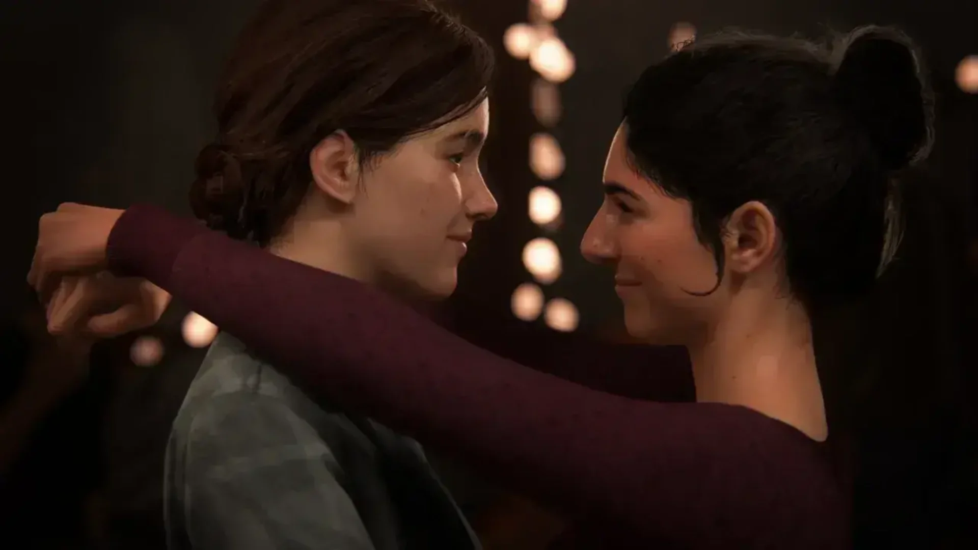 Two women share a quiet dance during a warmly lit scene in The Last of Us Part II.