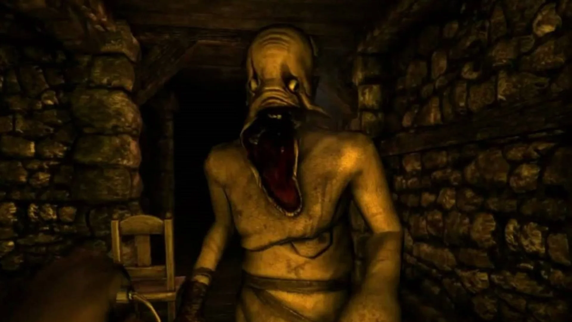 A grotesque humanoid monster with an open mouth approaches inside a narrow stone chamber.
