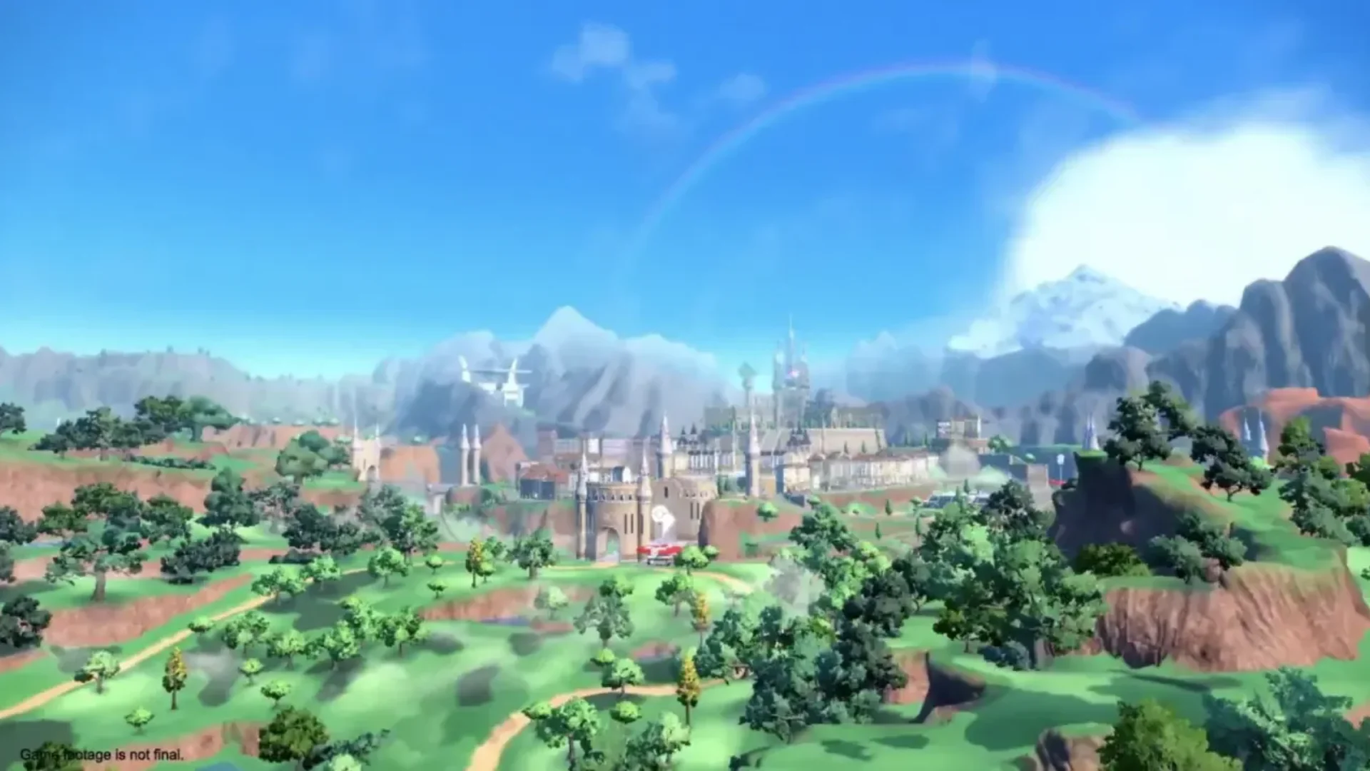 A wide view of Paldea shows a large city, green hills, mountains and a rainbow.