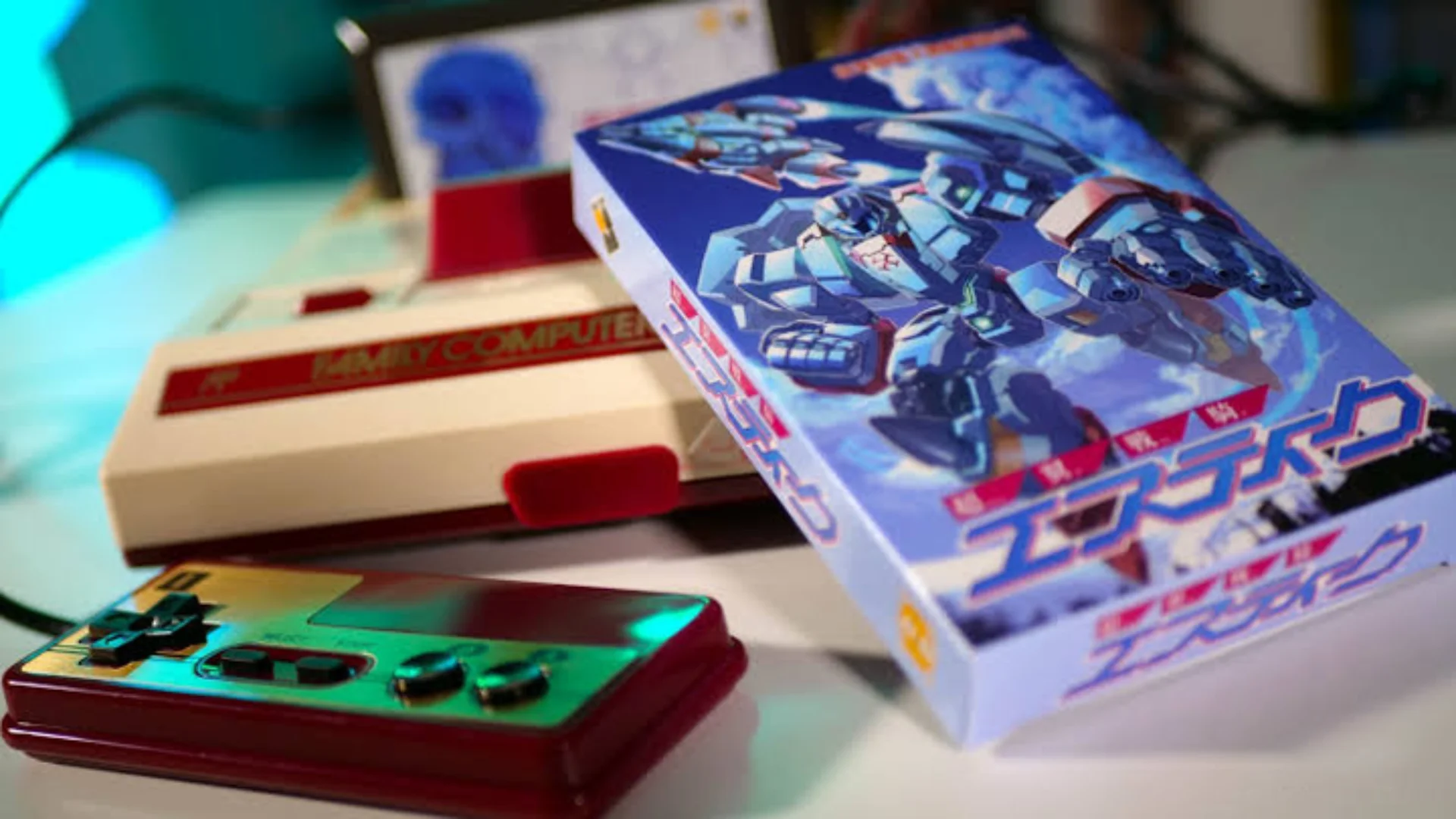 A Changeable Guardian ESTIQUE game box rests beside a Famicom console and controller.