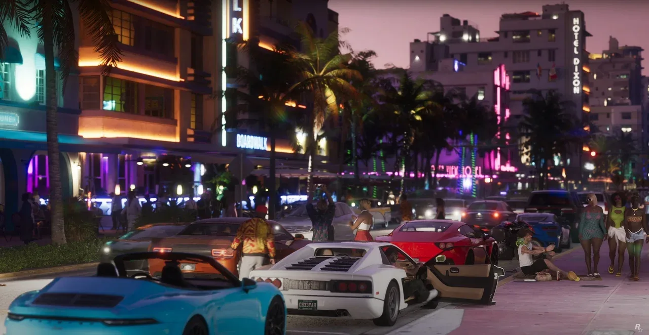 GTA VI screenshot showing a crowded Vice City street filled with cars, pedestrians, hotels, palm trees, and neon lights.