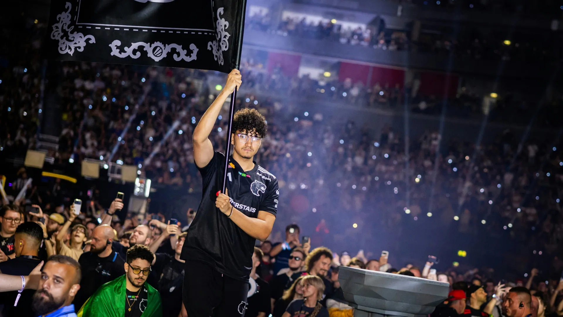 A FURIA player carries a team flag through the crowd at IEM Cologne Major 2026