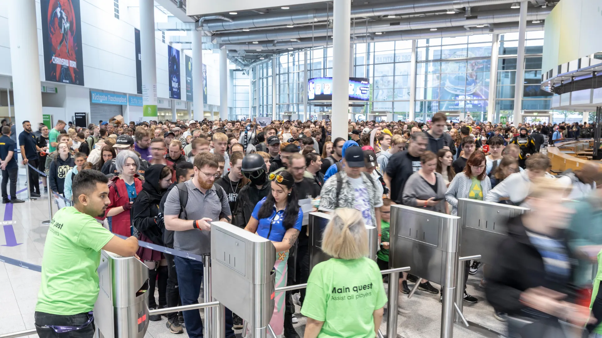 A large crowd enters Gamescom 2025 through turnstiles at Koelnmesse in Cologne.