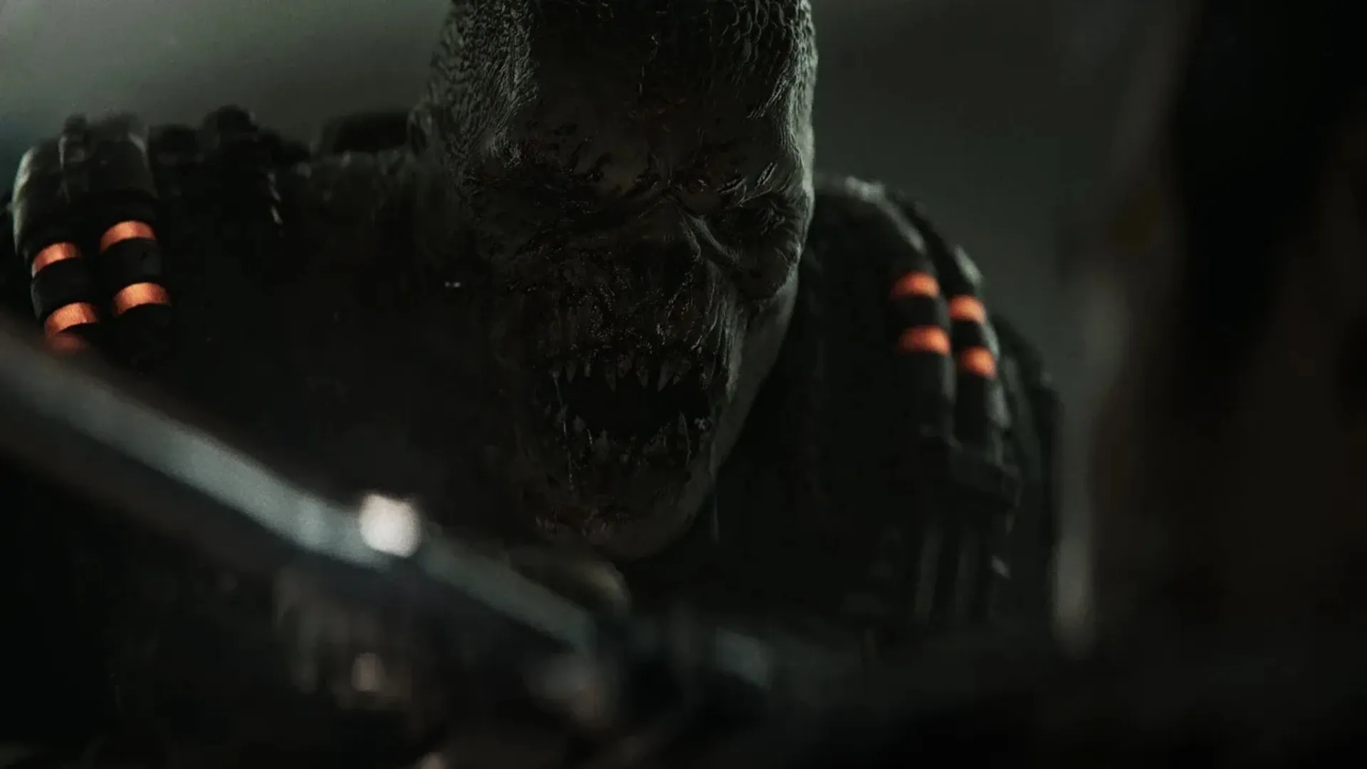 A hulking creature looms in a dark Gears of War: E-Day scene with orange lights on its armor.