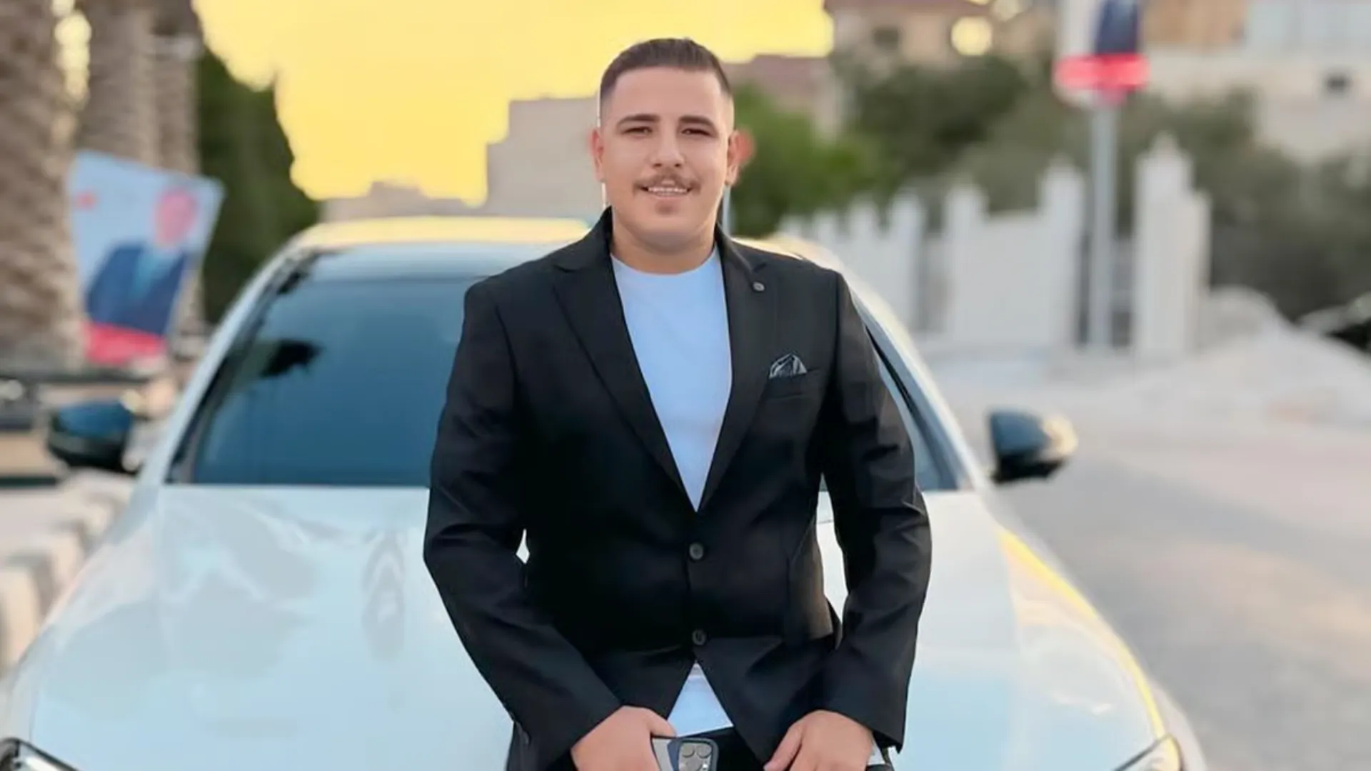 Jordanian content creator standing in front of a white car