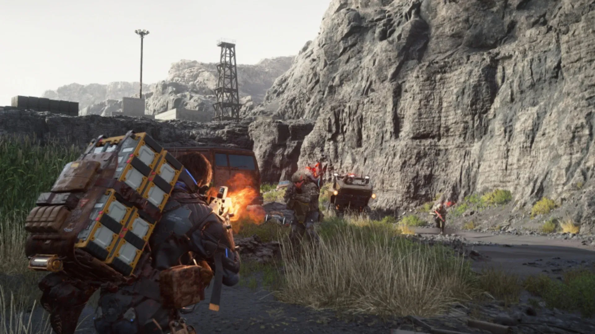 An armed PHYSINT character fires at soldiers beside vehicles in a rocky industrial area