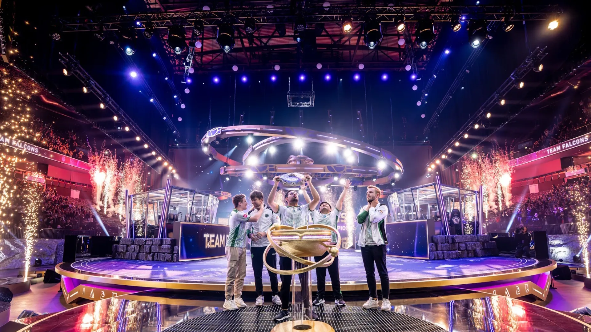 Team Falcons Dota 2 team posing with a championship trophy on stage