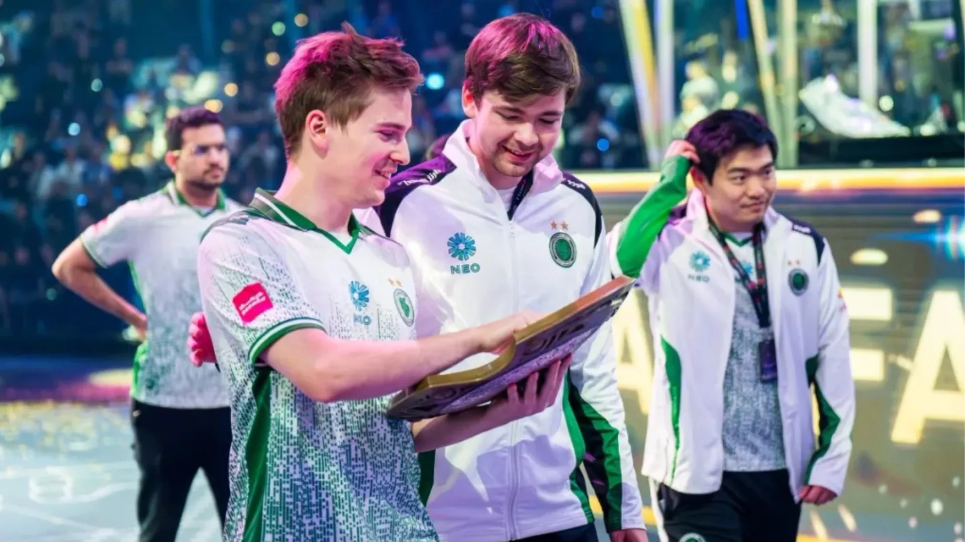 Team Falcons players looking at a Dota 2 championship trophy after a tournament win