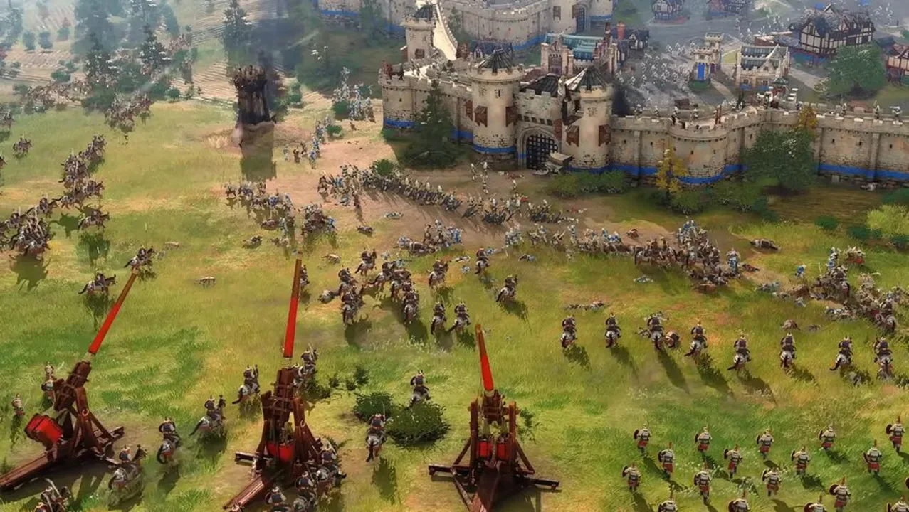 A large medieval army attacks a fortified castle with cavalry, infantry, and siege weapons in Age of Empires IV.