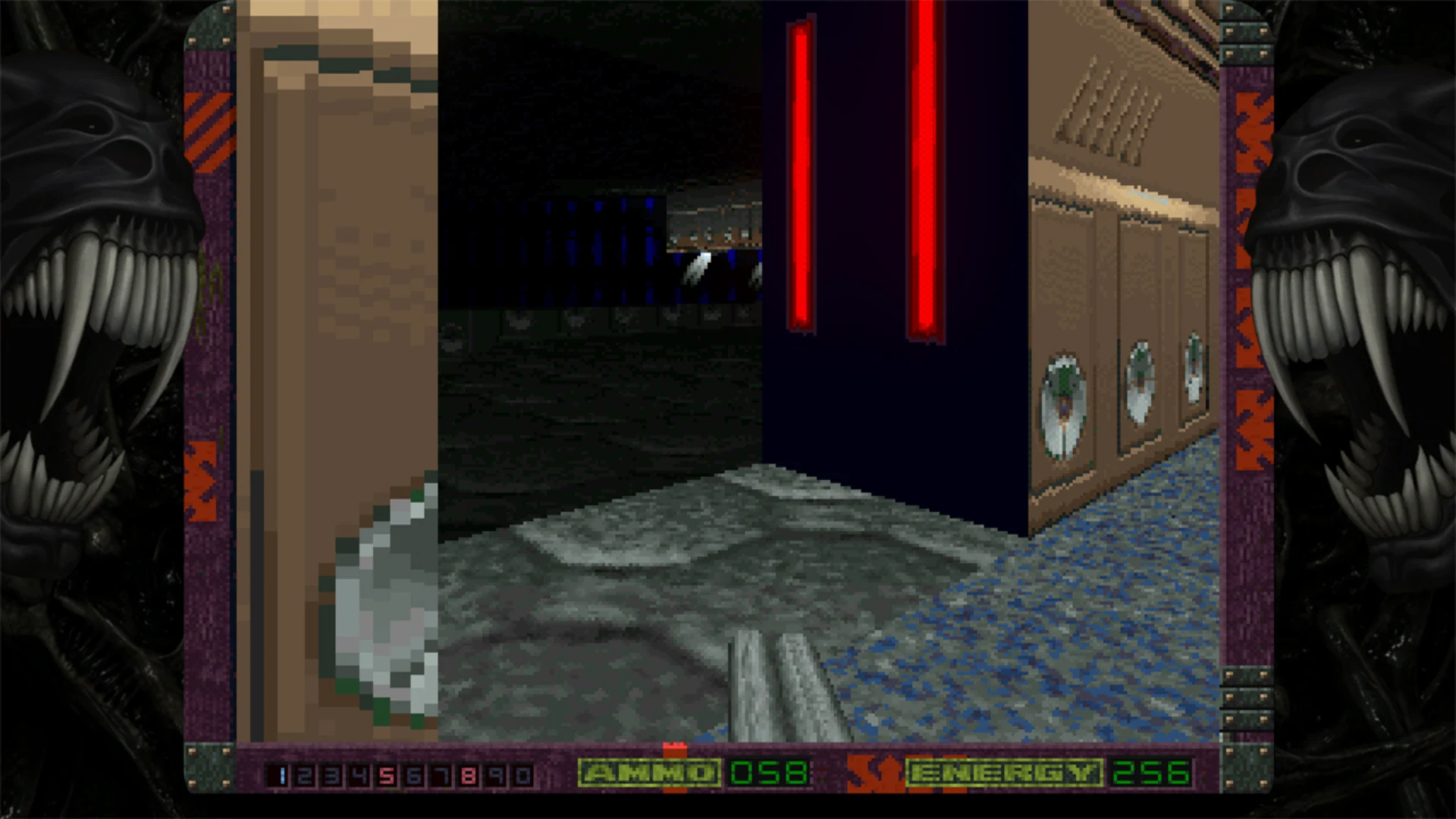The player explores a dim industrial corridor with red lights and metallic walls in Alien Breed 3D.