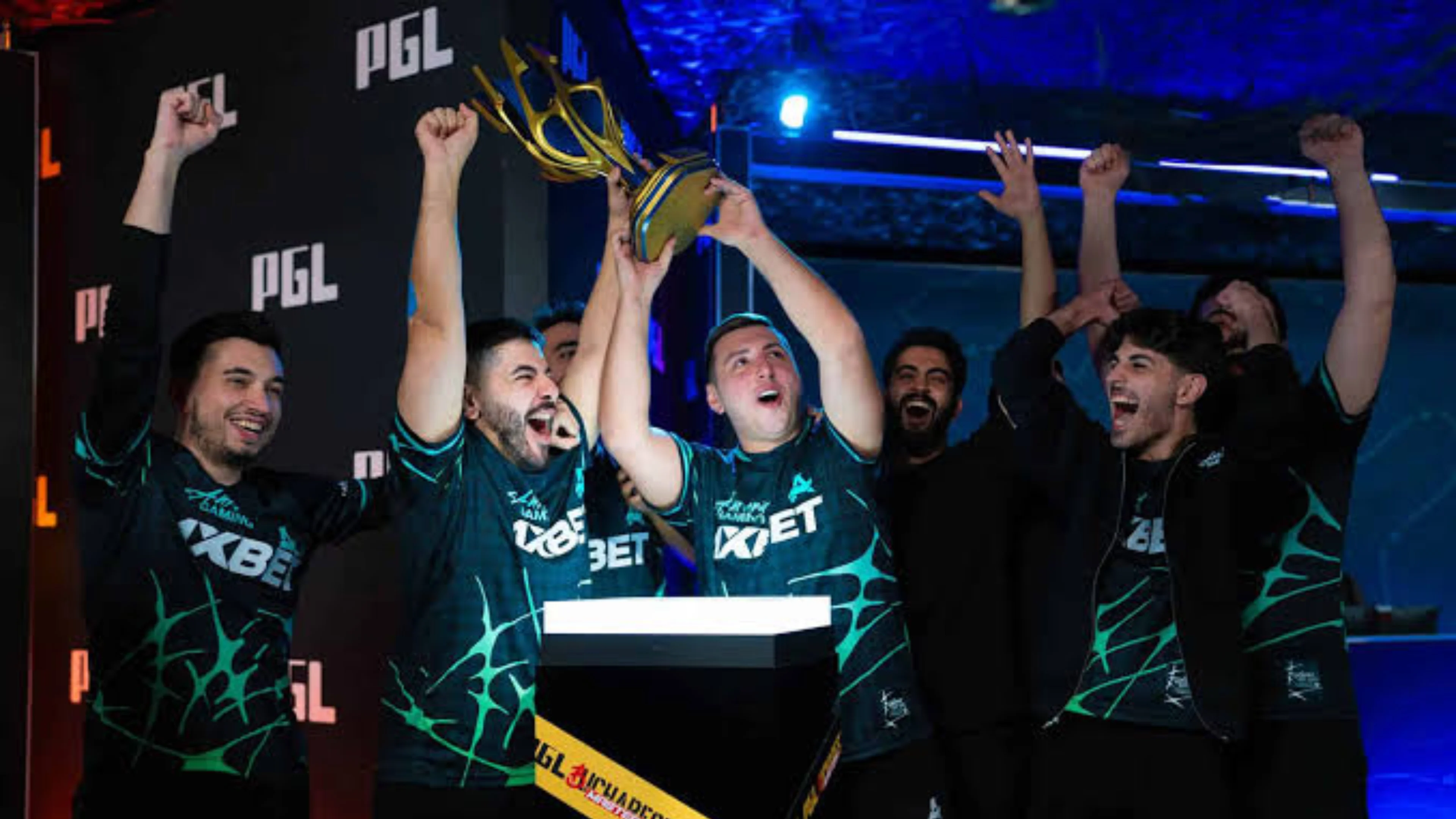 Aurora Gaming Counter-Strike players in dark jerseys celebrate around a golden PGL trophy with raised fists.