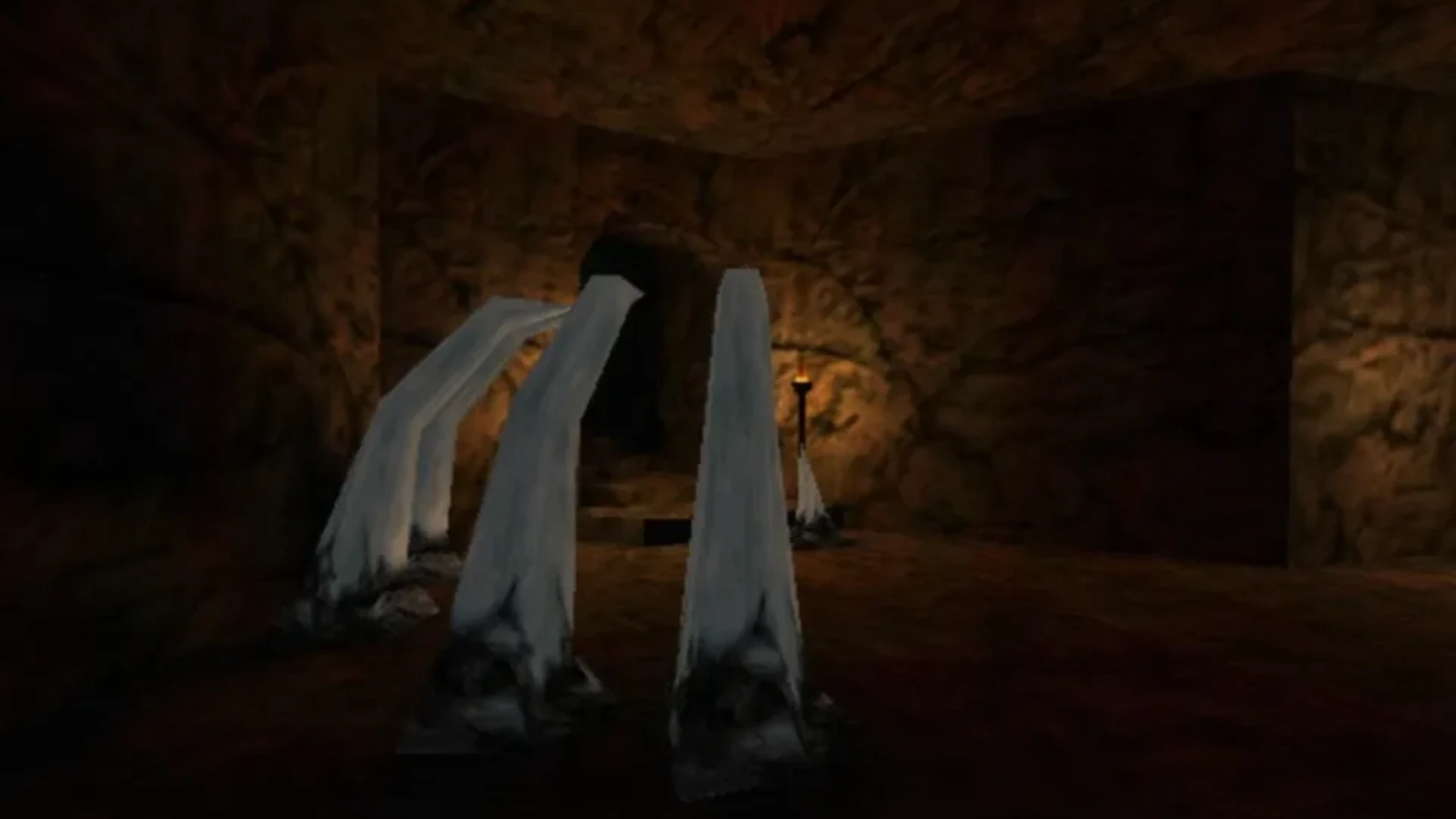 First-person gameplay in Thief II: The Metal Age showing the player exploring a torch-lit stone interior.