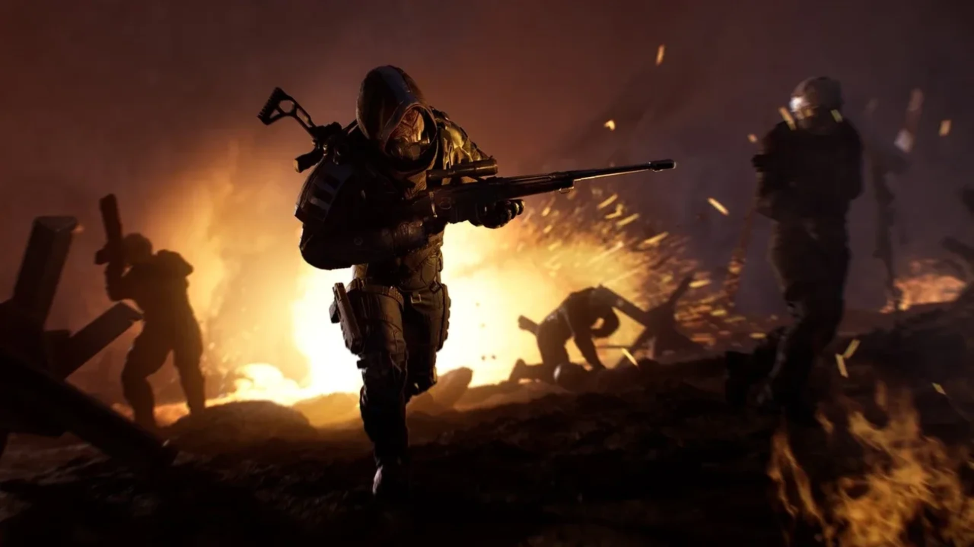 Outriders character carries a rifle through a battlefield illuminated by fire and explosions.