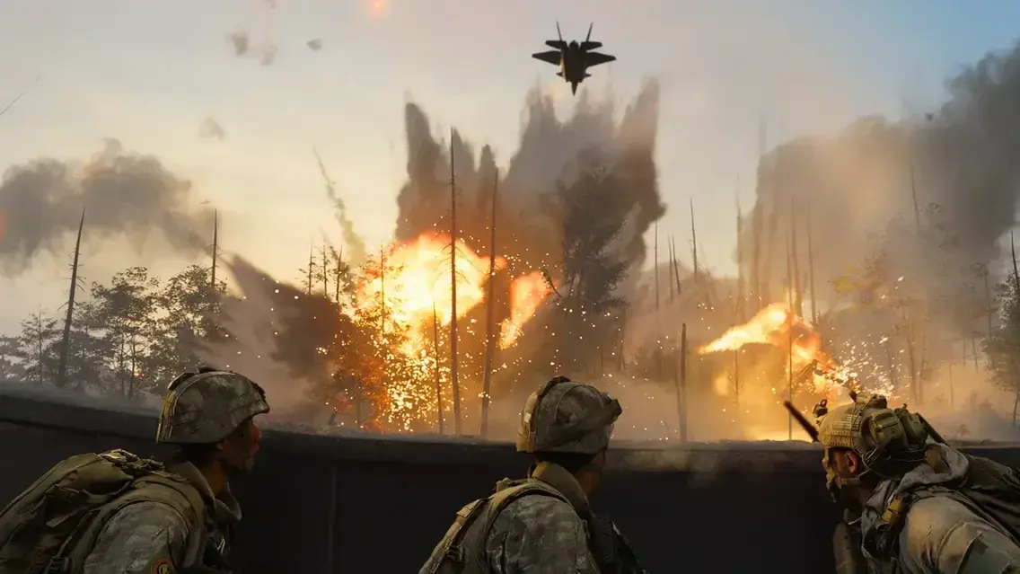 Three soldiers take cover behind a barrier as a fighter jet flies over explosions in a forest.