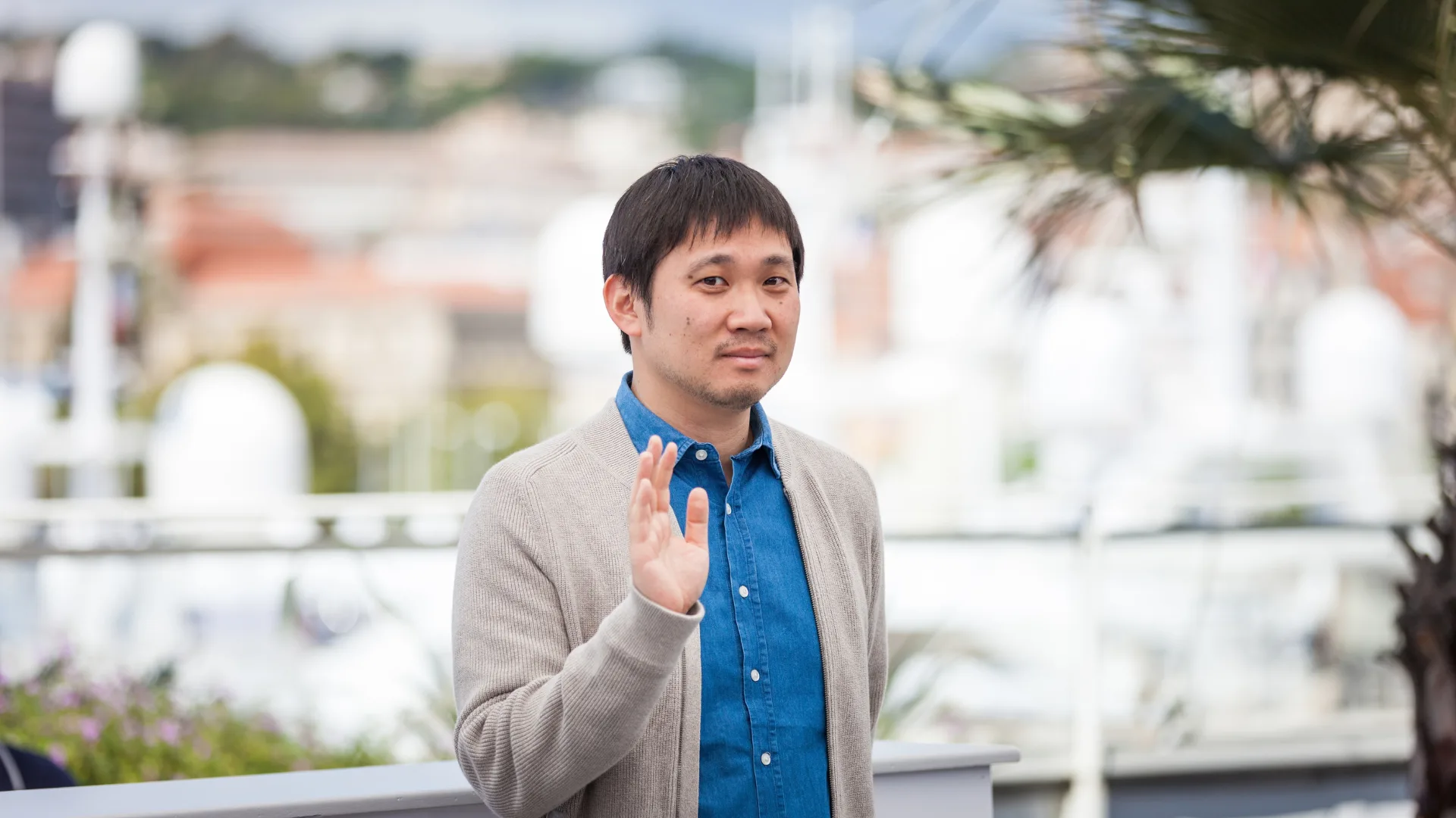 Hamaguchi developer standing outdoors and waving toward the camera