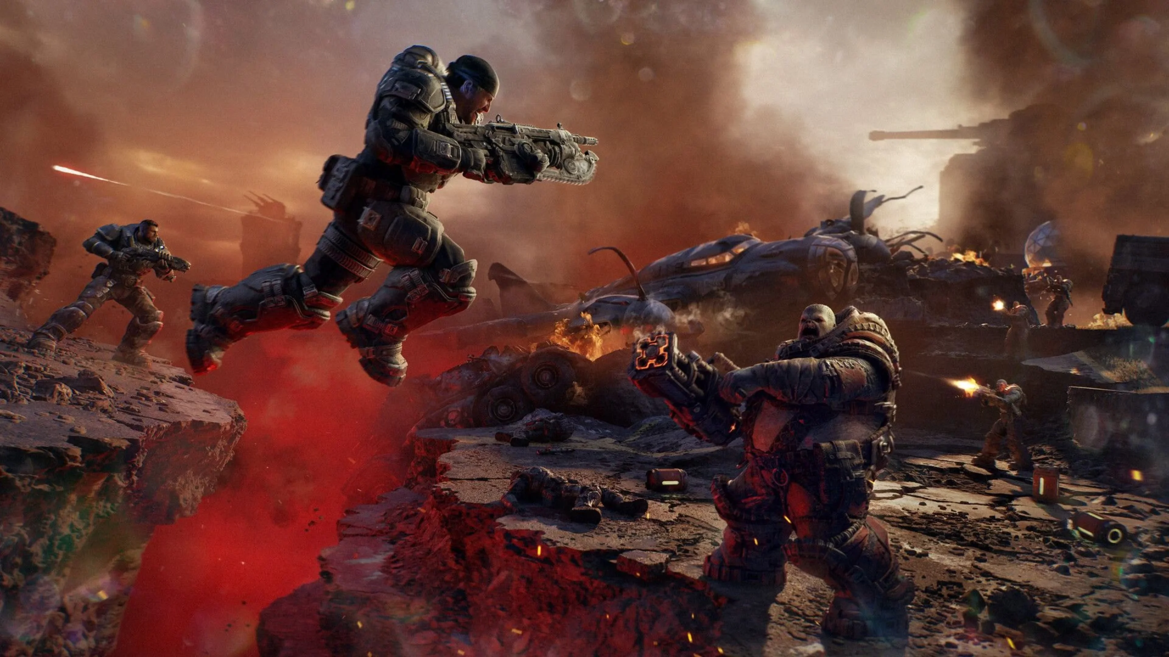 Armored soldiers fight amid explosions, burning wreckage and gunfire on a devastated battlefield in Gears of War: E-Day.