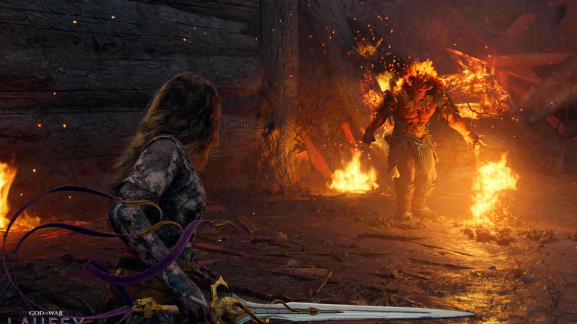 Faye holds her sword while facing a large burning enemy surrounded by flames in God of War Laufey.