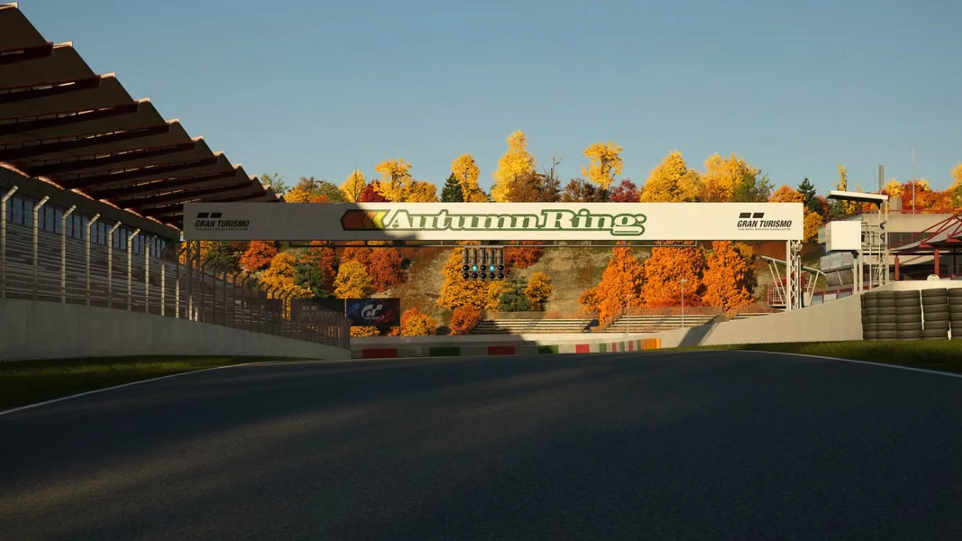 Gran Turismo 7 shows the returning Autumn Ring circuit with its start and finish straight framed by colorful autumn foliage.