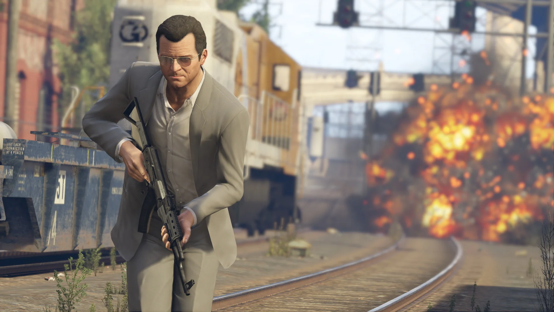 Grand Theft Auto V gameplay shows Michael moving along railway tracks with a rifle as a large explosion erupts behind him.