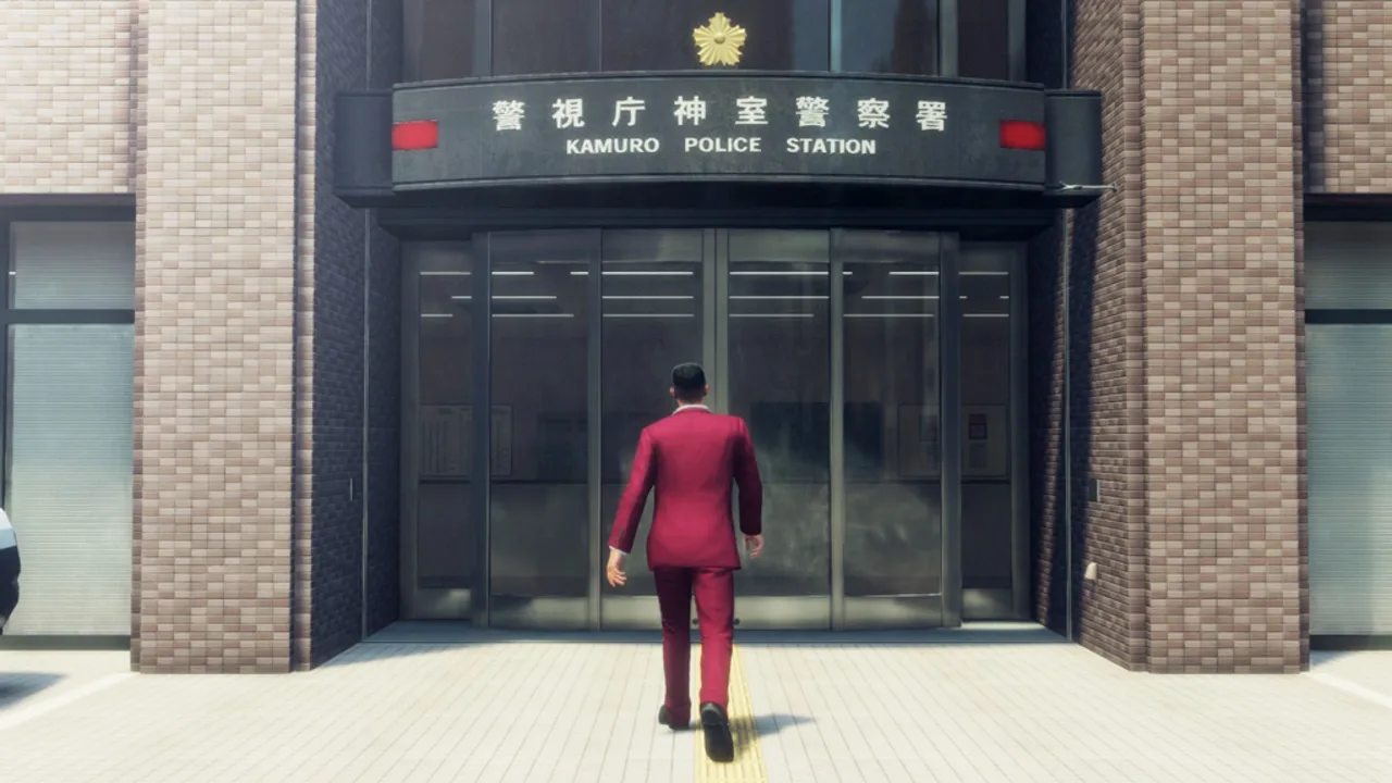 A man in a red suit approaches the Kamuro Police Station in the Like a Dragon series.