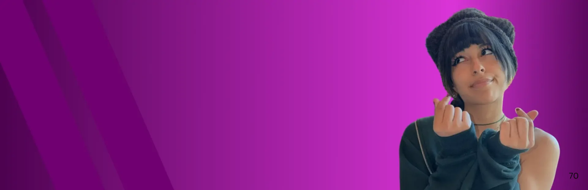 A smiling person wearing a dark knit hat makes finger-heart gestures against a bright pink background.