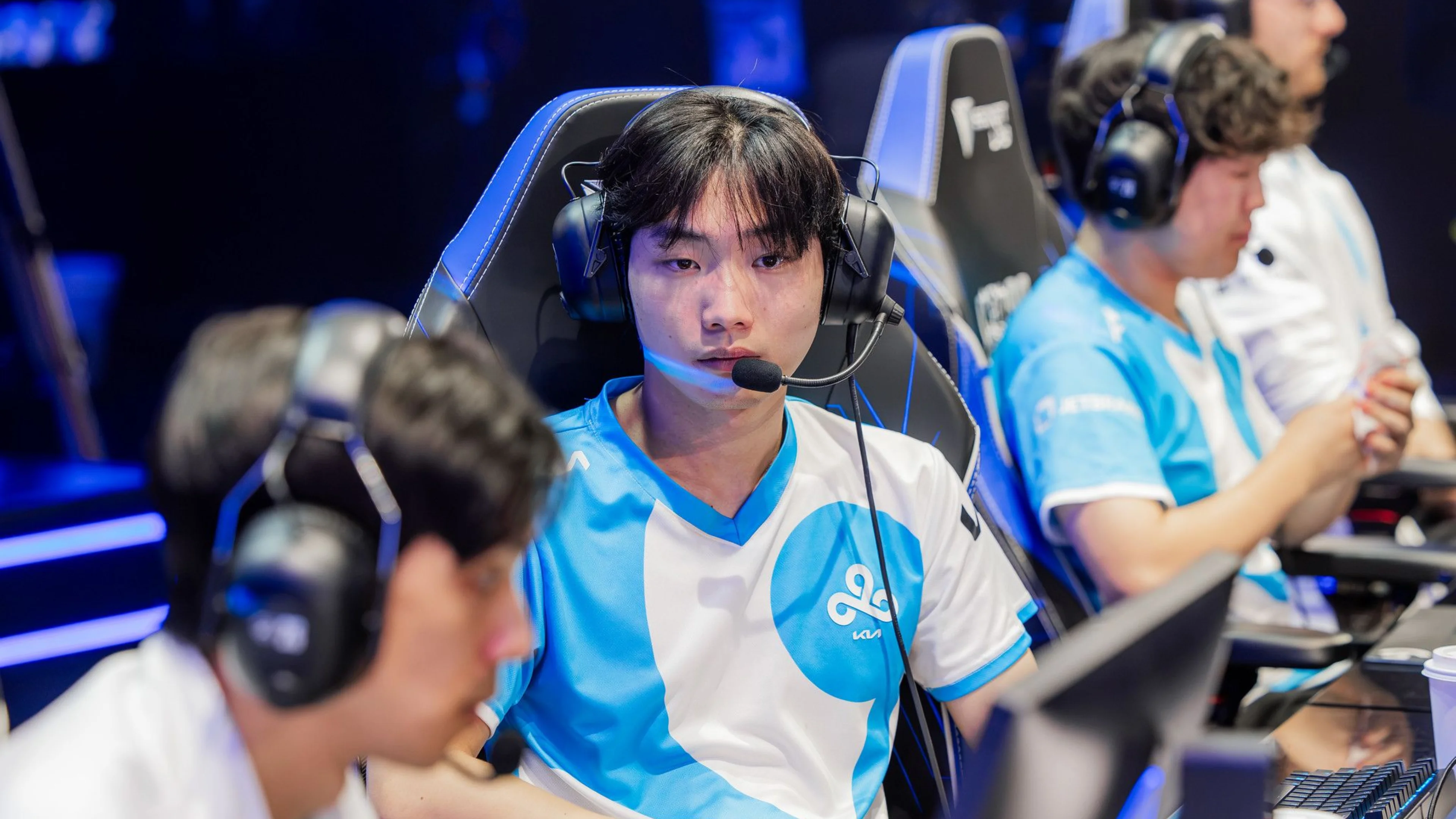 Cloud9 League of Legends player wearing a blue and white jersey and headset while competing at an esports event.