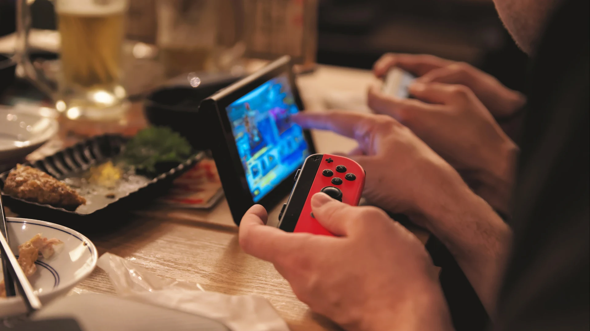 Player holding a red Joy-Con while playing Nintendo Switch in tabletop mode