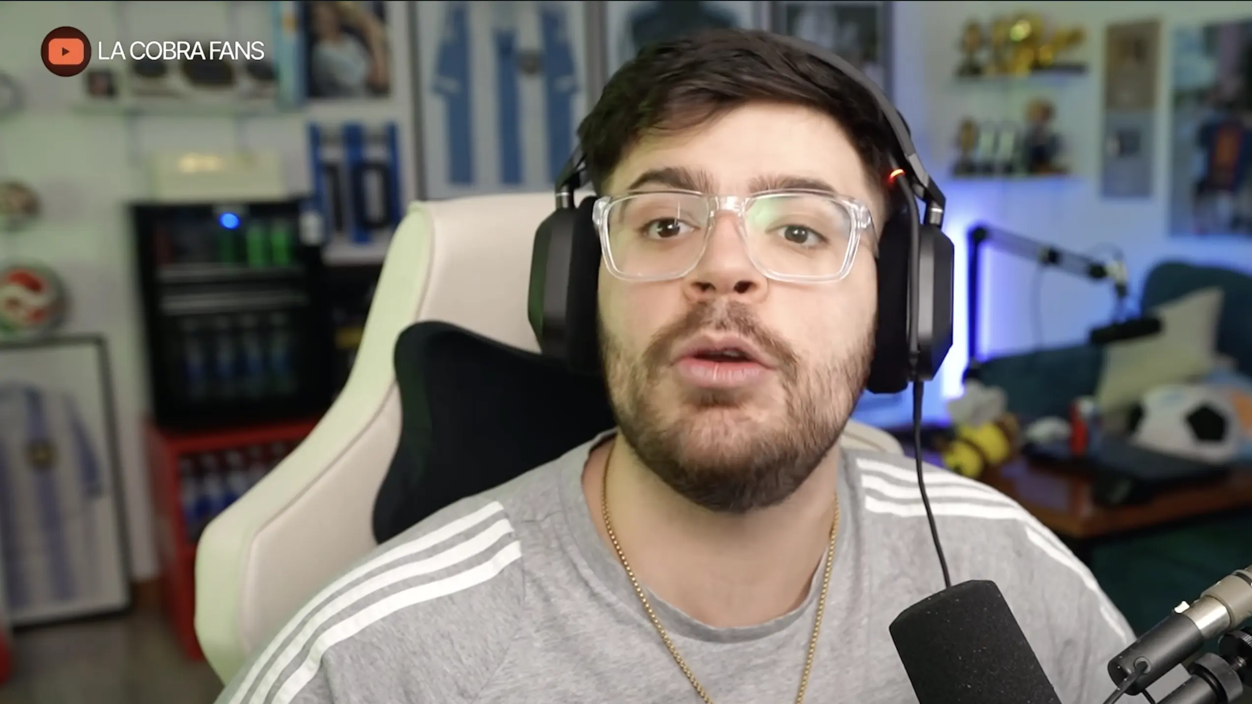LA COBRA wearing glasses and headphones while speaking into a microphone during a livestream.