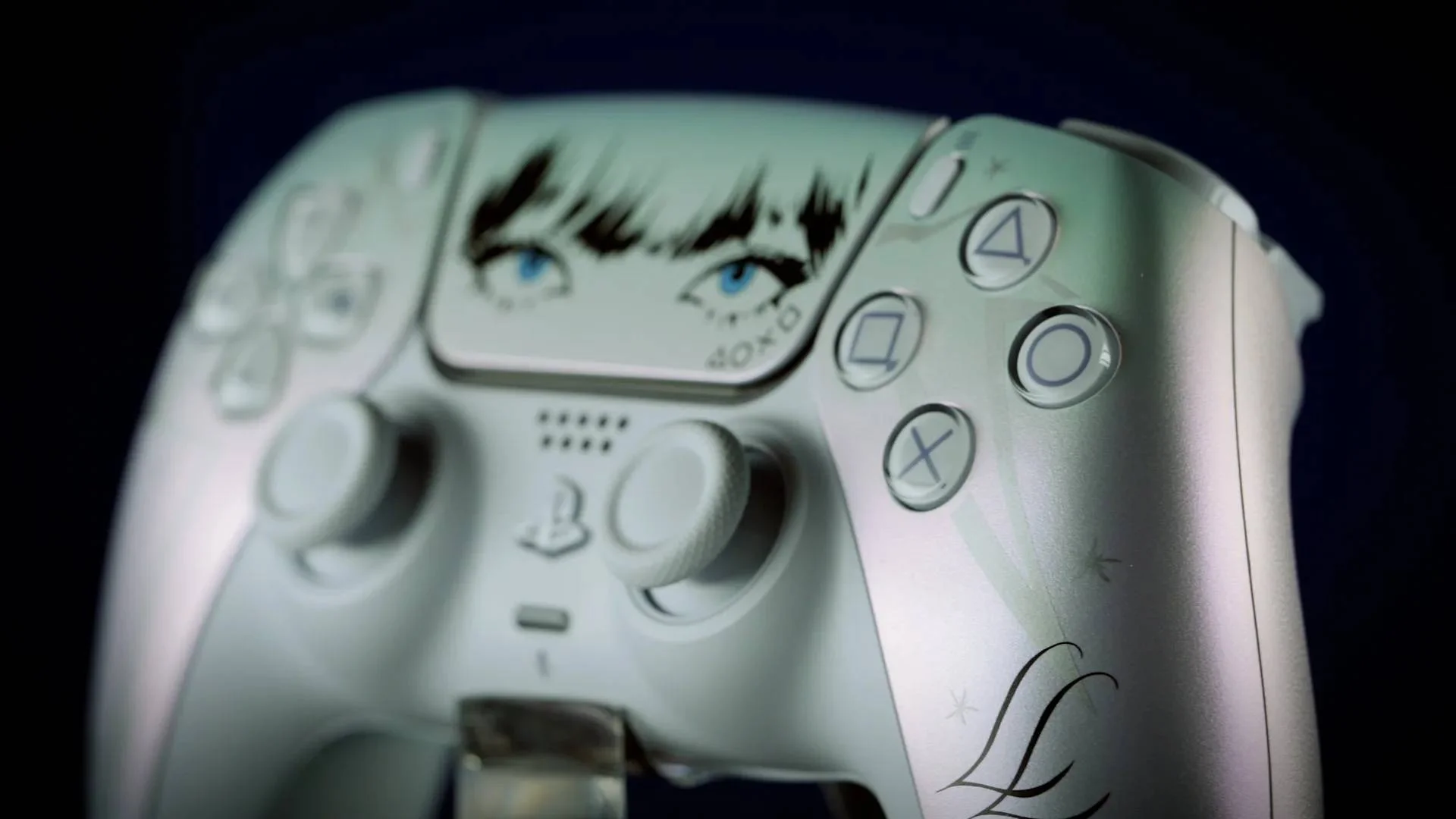 Close-up of the white LISA Limited Edition DualSense showing illustrated eyes, stars, and LL lettering.