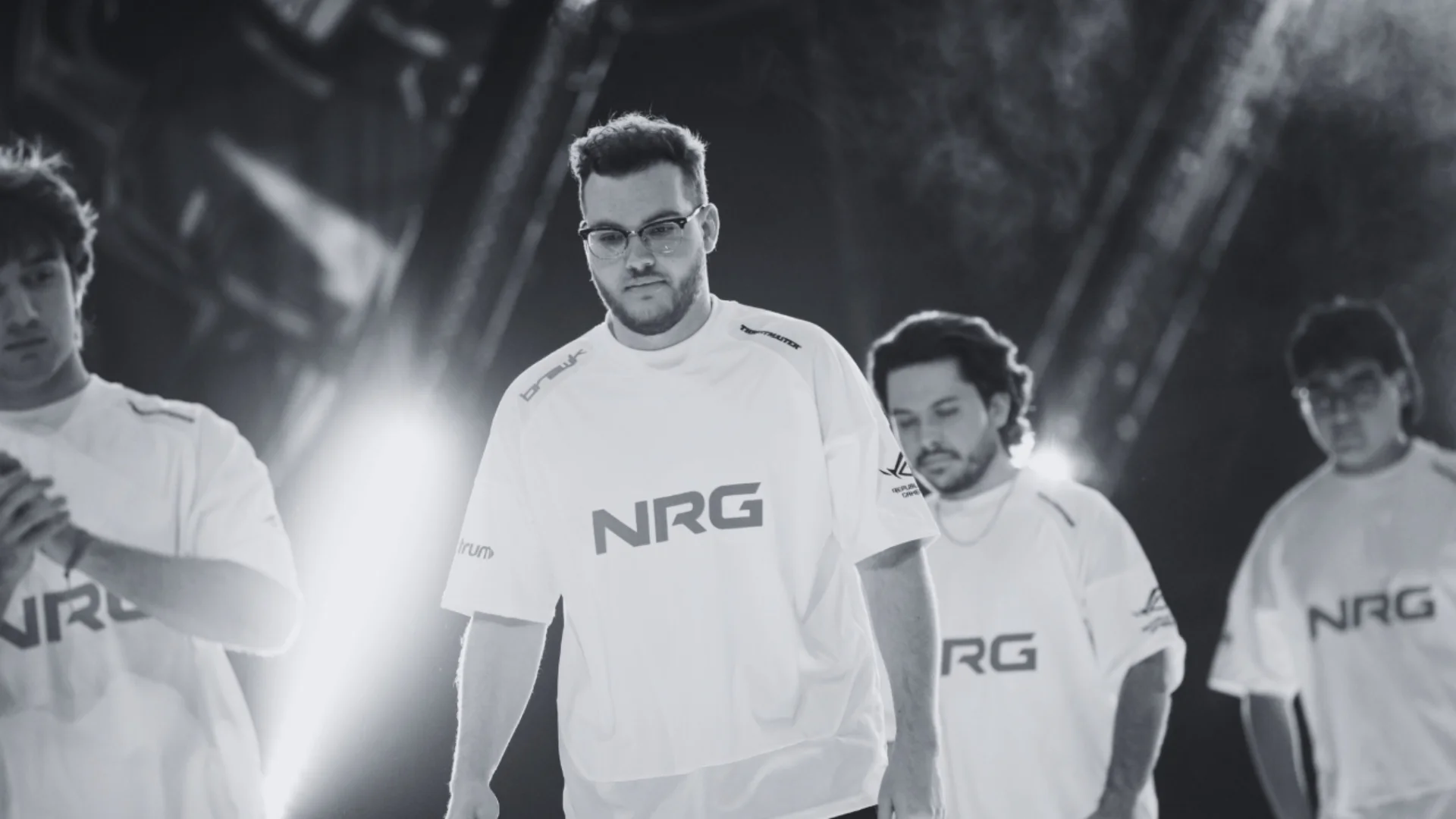 NRG Counter-Strike players in white jerseys stand together beneath bright stage lights in a black-and-white team photo.
