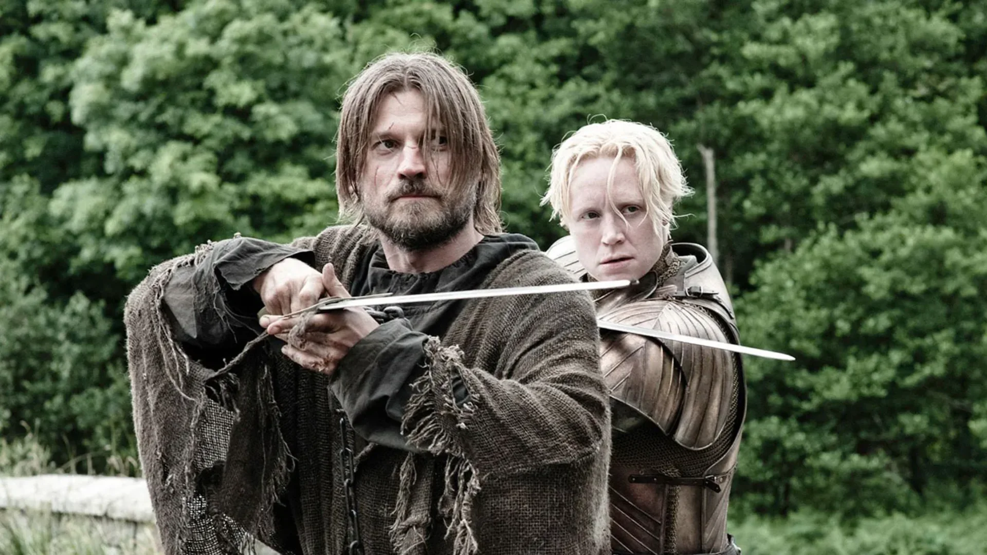 Two sword-wielding warriors face forward outdoors, with one holding a blade across the other person's chest.