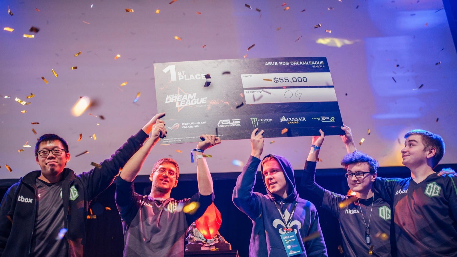 OG esports players celebrating first place at the ASUS ROG DreamLeague while holding a $55,000 prize check.