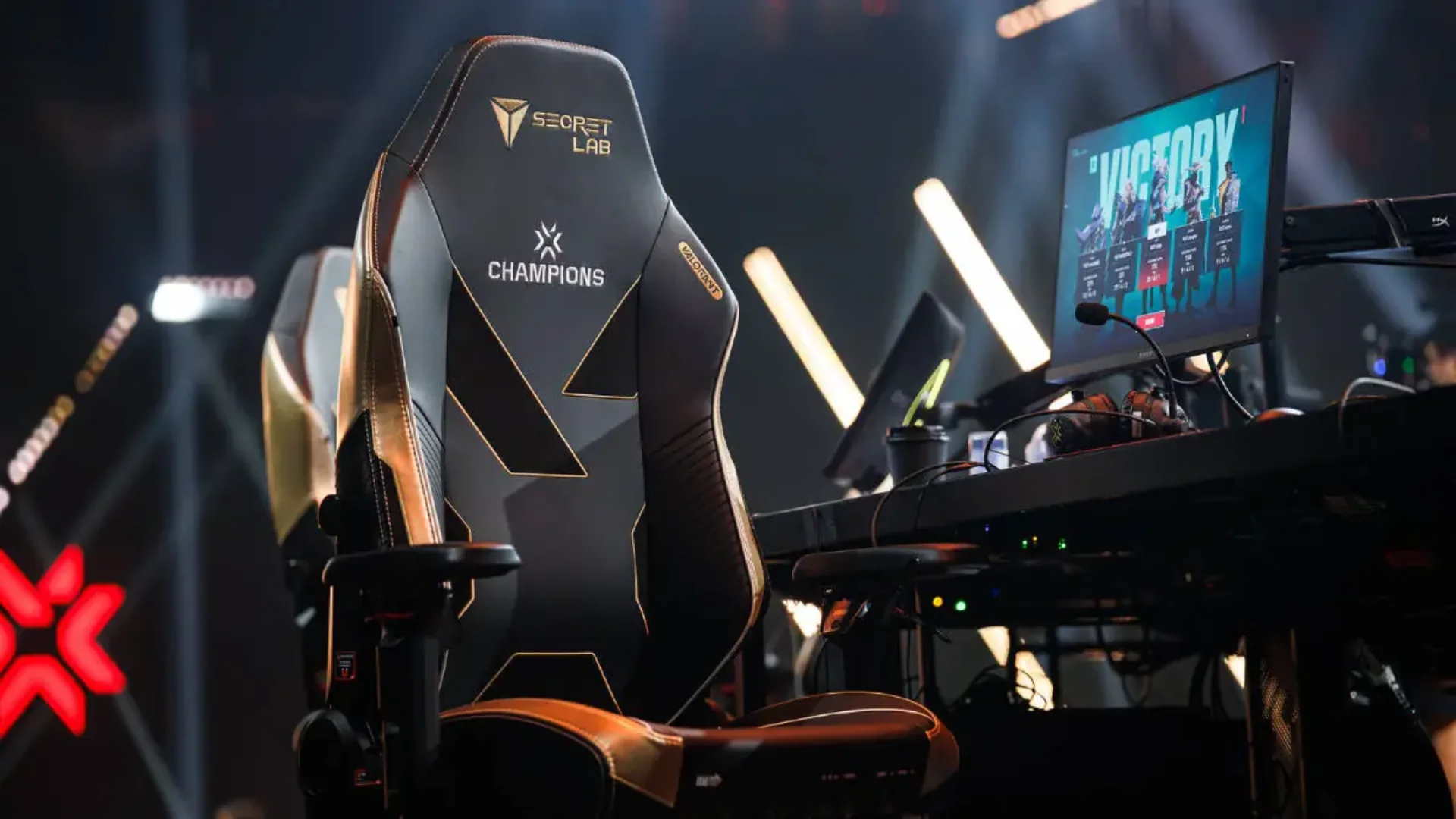 A VALORANT Champions gaming station shows a Secretlab chair, monitor, keyboard and tournament equipment.