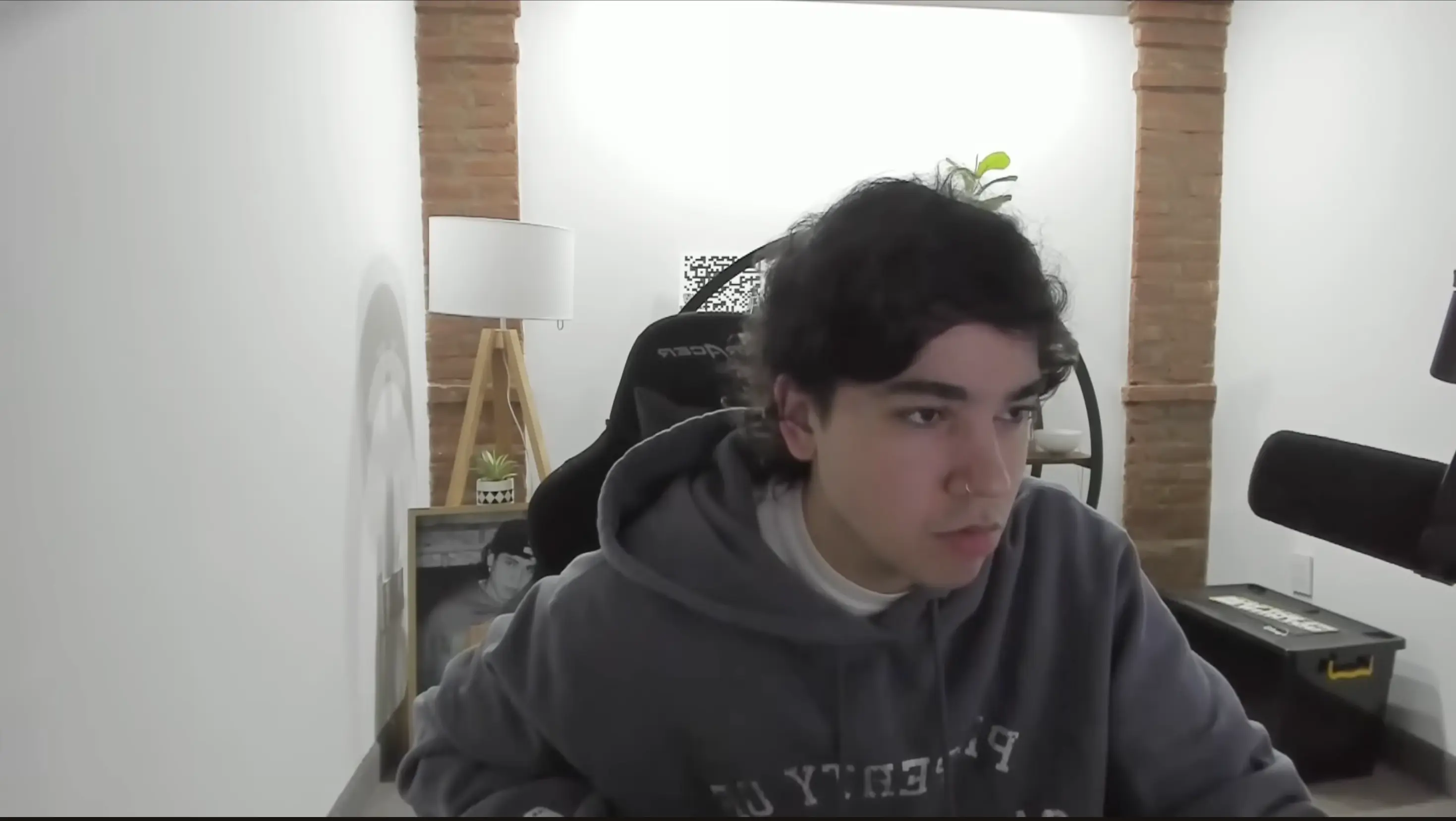 Spreen sitting in a gaming chair beside a microphone during a livestream.