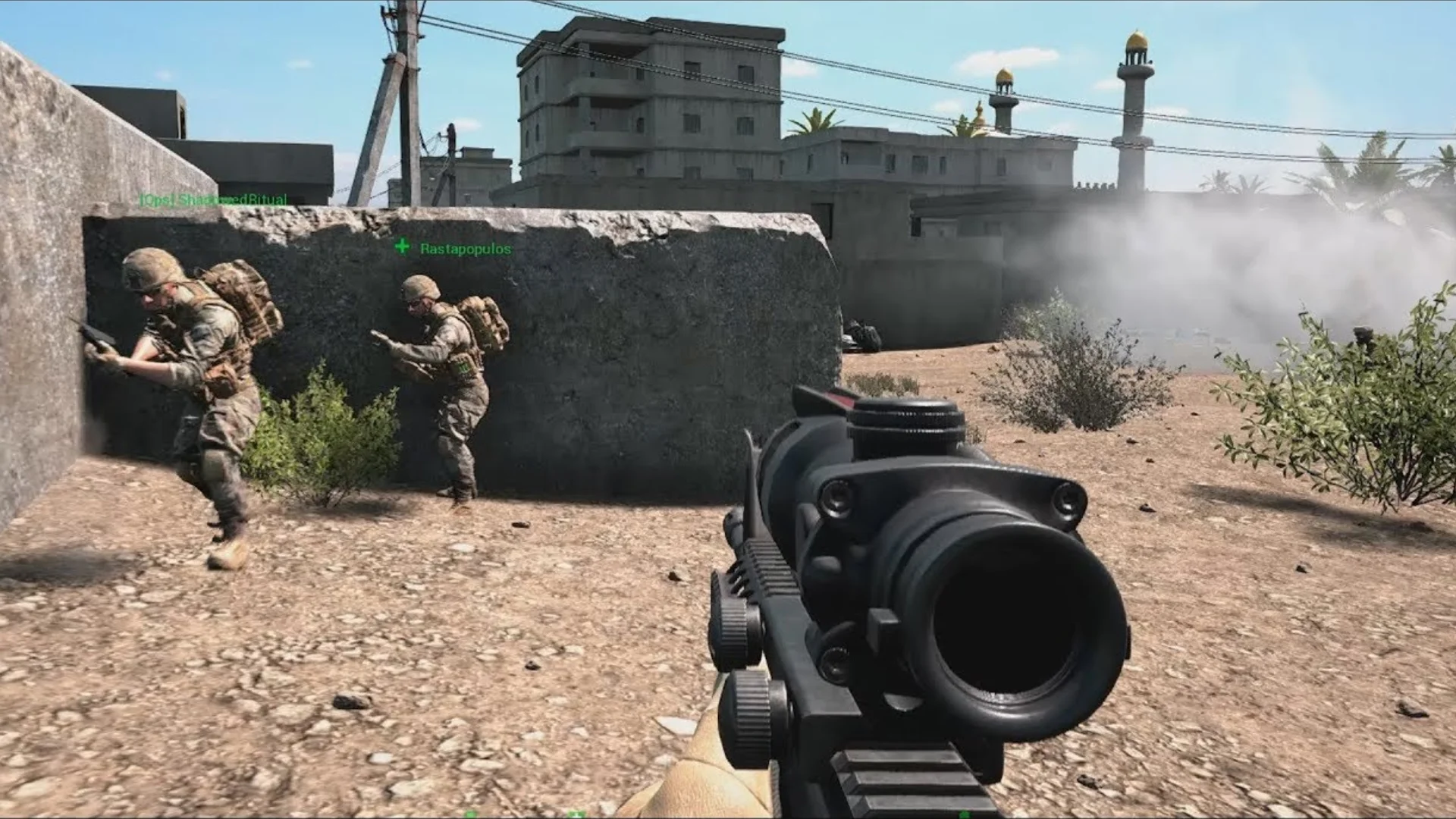 Squad gameplay shows two soldiers taking cover behind a concrete wall while smoke fills an urban battlefield.