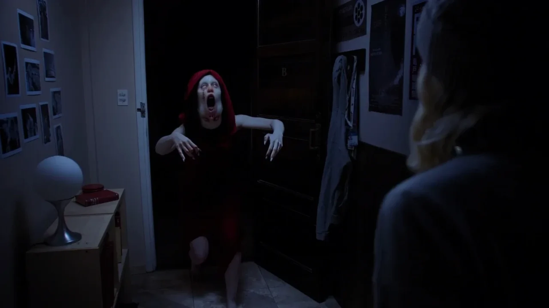 Pale figure in a red hood lunges from a doorway during a Tenebris Somnia live-action scene