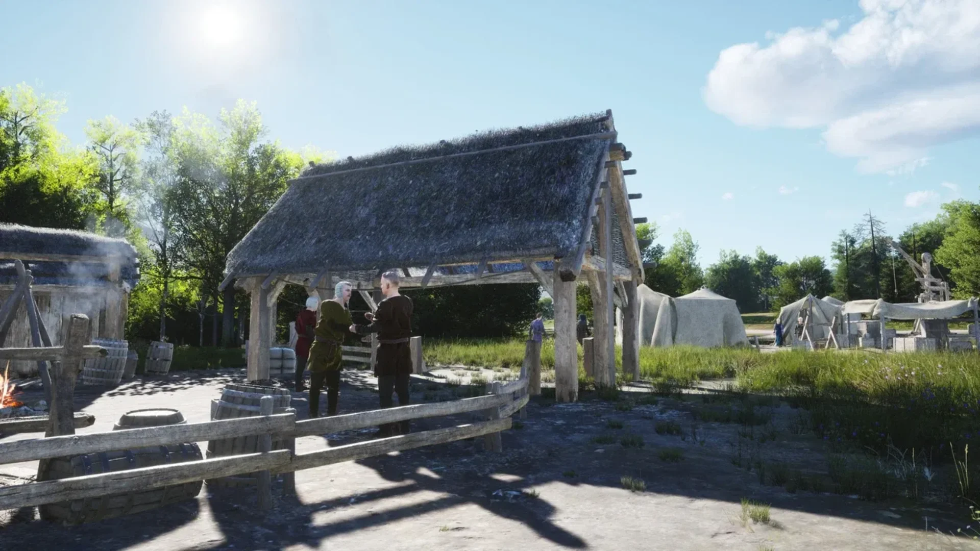 Villagers gather beneath a timber shelter beside tents in a medieval Manor Lords settlement.