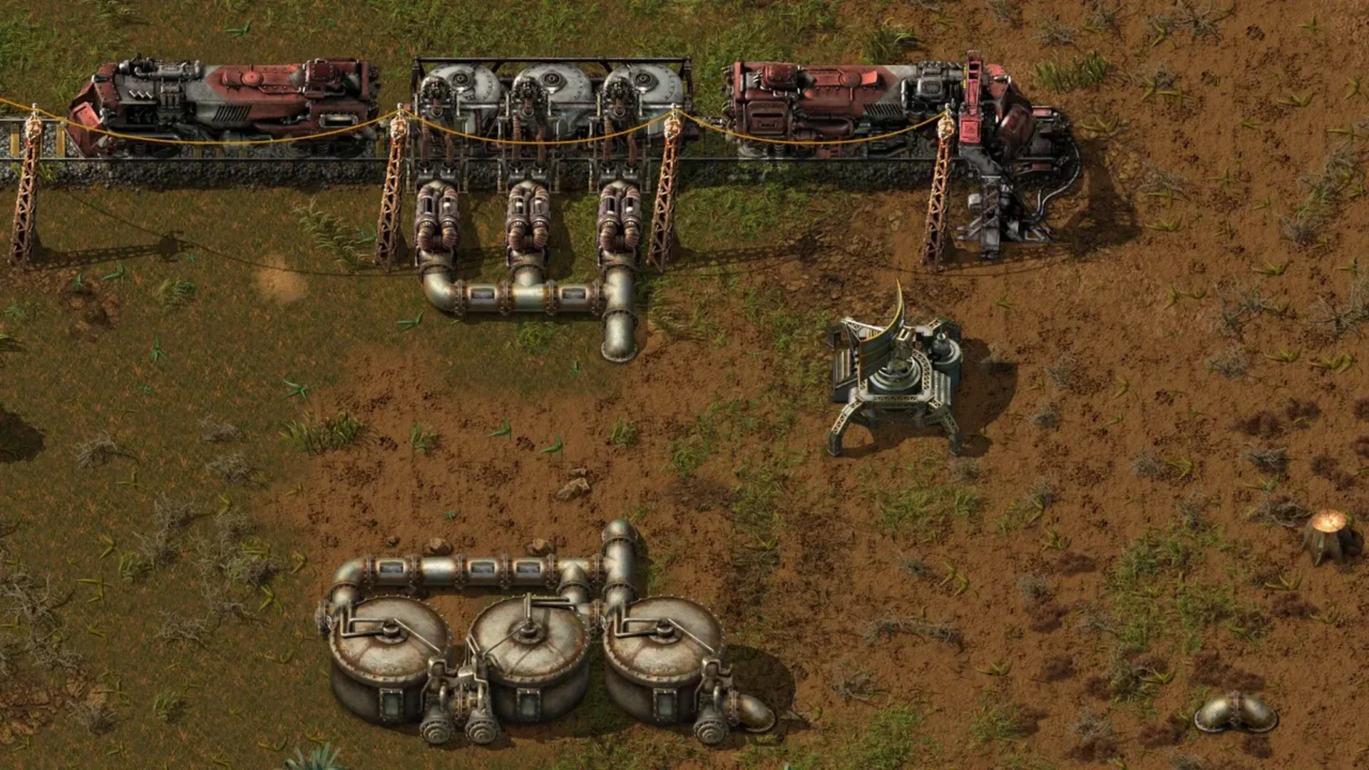 Factorio factory setup with pipes, storage tanks, machinery, power poles, and industrial equipment.