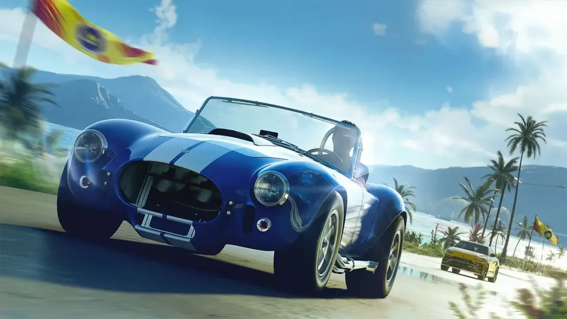 Blue Shelby Cobra racing along a tropical coastal road in The Crew Motorfest