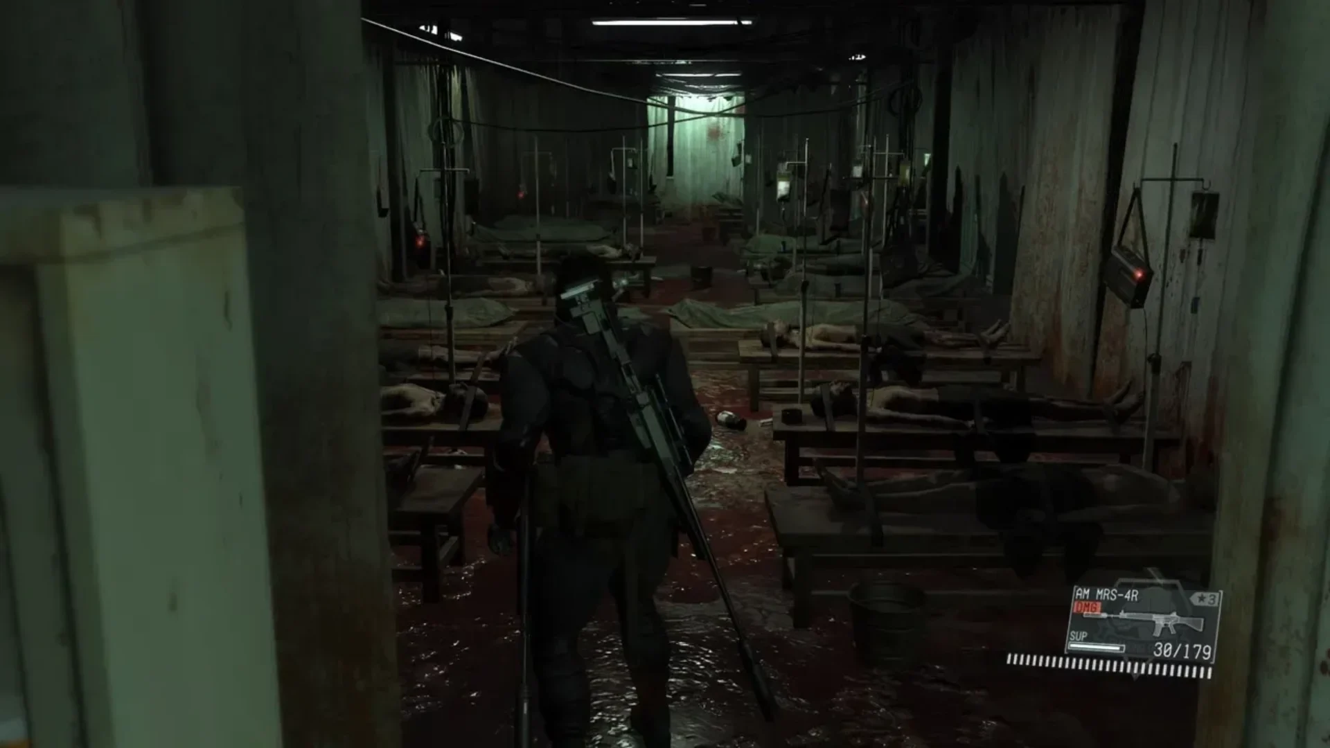 Venom Snake explores a dark hospital ward in Metal Gear Solid V: The Phantom Pain