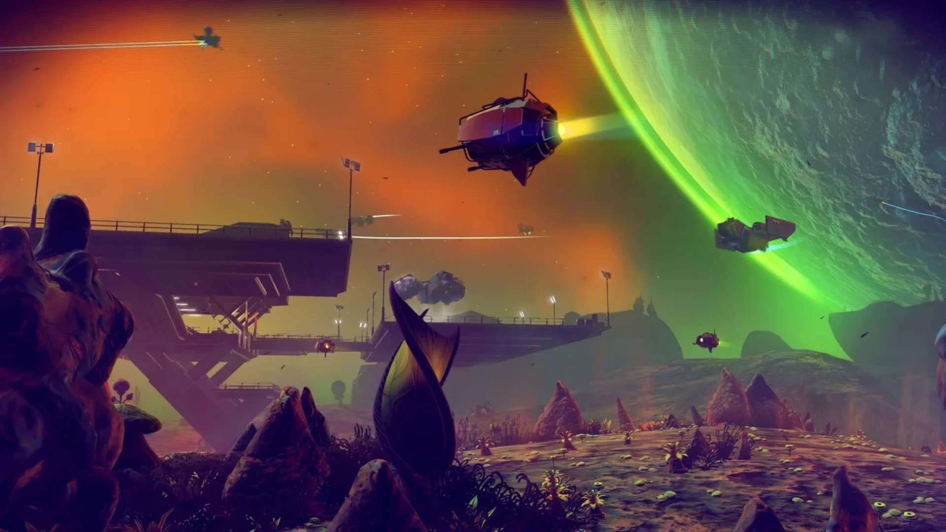 No Man's Sky alien landscape with several starships flying beneath a huge green planet.